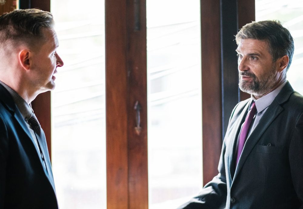 Two businessmen in conversation by a window