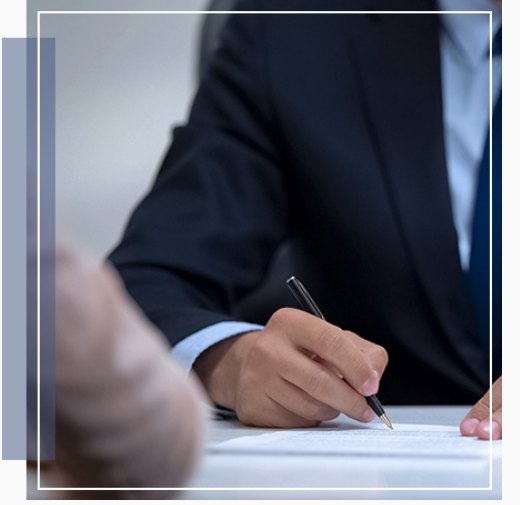 A professional signing a business document