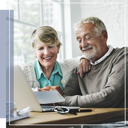 An older couple reviewing documents on a laptop