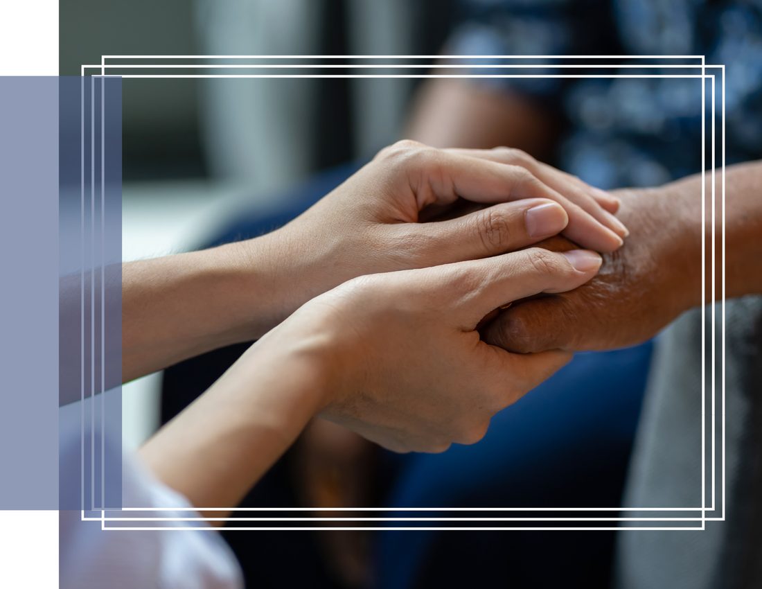 A caregiver holding an elderly person&rsquo;s hands