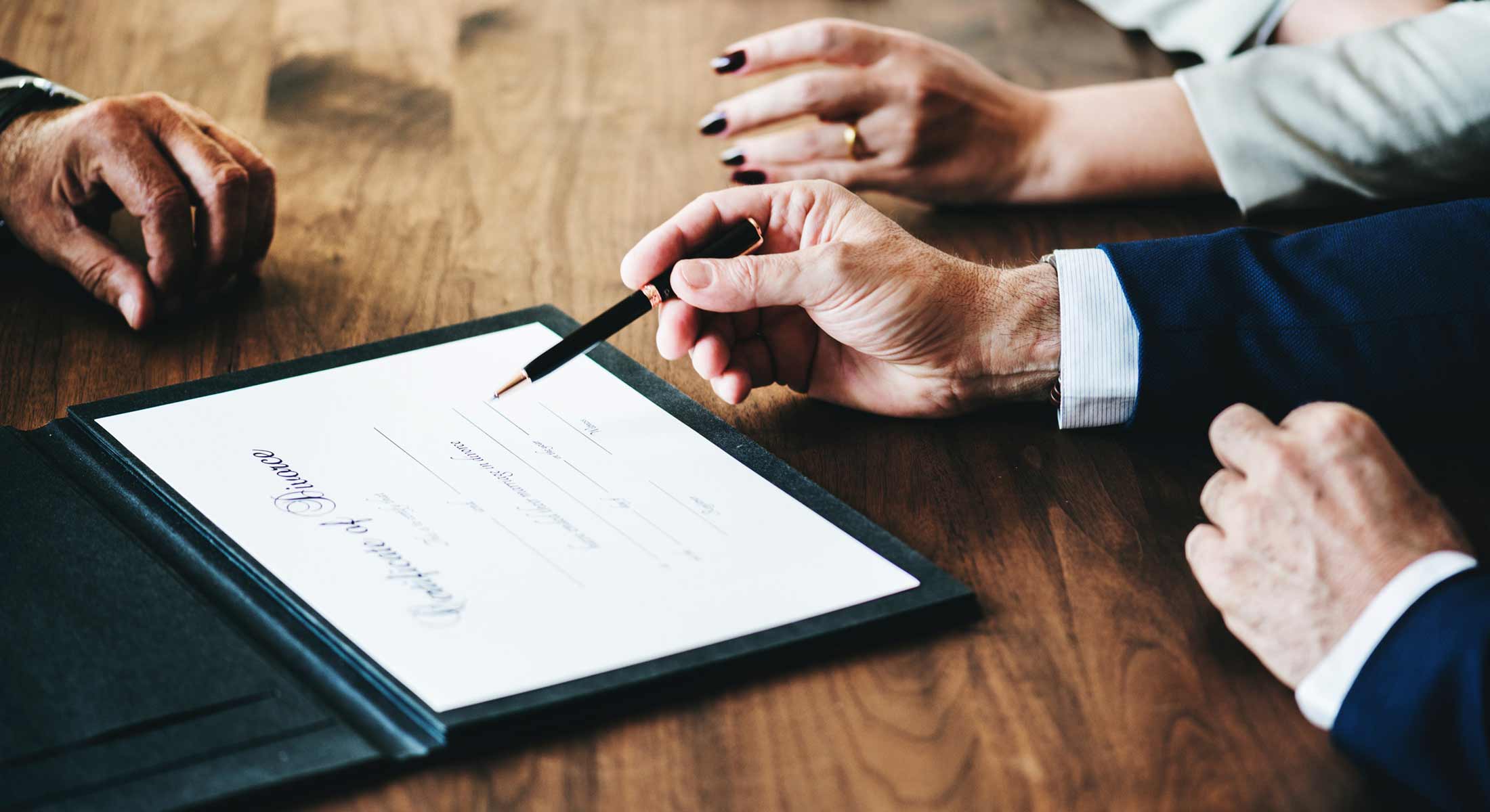Attorney signing estate planning documents with clients